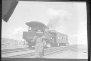 [Railway engine & car with person in foreground]