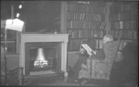 George Eastman reading a book in Little Library