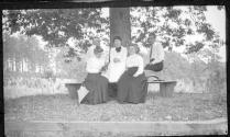 Oak Lodge guests sitting on bench around tree