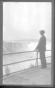 [Man at observation area, falls in distance]