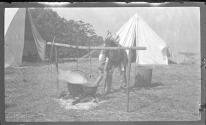 [Man in indian costume by campfire]
