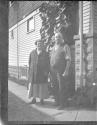 [Man & woman by side of house]