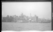 [View of ferry boat slips, city skyline in distance]