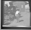 Boy standing near horse drawn carriage