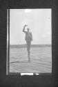 [Man on dock post tipping hat]