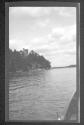 [House on bank above river]