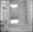 Man standing next to door to garden