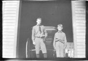 Two boys standing in front of carriage house