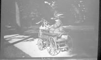 Children dressed as indians in toy cart