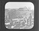 [Man giving speech to group of seated soldiers]