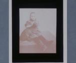 [Little girl with dachshund, her feet towards camera]