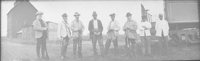 George Eastman and companions standing by a railroad car