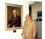 Stanley Gordon next to his painting of George Eastman