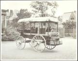 Wagon containing Eastman's camping gear in carriage house yard between carriage house and laundry yard