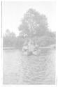 George Eastman operating motion picture camera on platform on canoes, Grand Cascapedia Trip