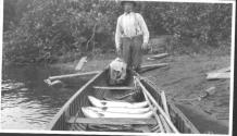 Man with canoe, three large fish inside, Grand Cascapedia Trip