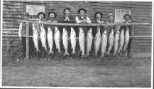 Fishing companions posing with fish, Grand Cascapedia Trip
