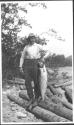 Man on log holding fish, Grand Cascapedia Trip