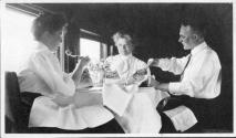 George Eastman dining with Eleanor Eastwood and Josephine Dickman in railroad car, Wyoming Trip