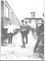 Three men standing near rail car, Oak Lodge trip