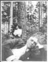 Josephine Dickman and Walter Hubbell relaxing by trees, Oak Lodge Trip