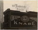 [Side of W.F. Frederick Pianos Building with painted sign and electric sign]