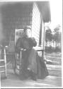 Josephine Dickman in rocking chair on porch, Oak Lodge Trip