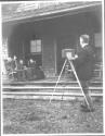 George Eastman photographing guests on porch, Oak Lodge Trip