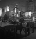[Old woman with a basket sitting in a store]