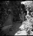 [Ansel Adams walking on sidewalk wearing an apron]