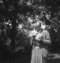 [Beaumont Newhall holding a cat]