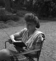 [Woman looking at an album]
