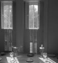 [Glasses and plates by window shutters]