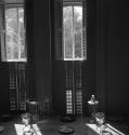 [Glasses and plates by window shutters]