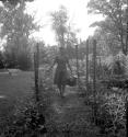 [Woman in a garden with a basket of vegetables]
