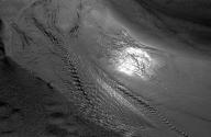 [Water ripples along sand of beach]