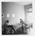 [Couple lounging on beds]