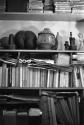 [Books and artifacts on cluttered shelves]