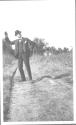 Walter Hubbell standing in road waving, Oak Lodge Trip