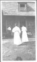 Two women walking toward George Eastman, Oak Lodge Trip
