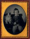 [Boy and dog sitting side-by-side in chair]