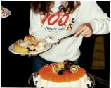 [Close up of woman spooning a portion of molded gelatin dessert onto plate]