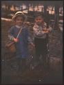 [Kate Marion Hosley and John Oak Hosley, Kate with fishing rod and creel, John with shotgun]