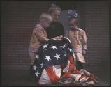 [Kate Marion Hosley with children Marion Burt Hosley and John Oak Hosley grouped around American flag]