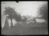 [Group gathered outside tents]