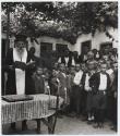 [Greek Orthodox priest conducting services for children being evacuated from the village of Promahi]
