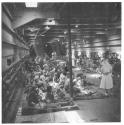 [Children seated on blankets, interior of ship]