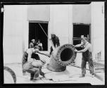 [Plumbers with large pipe elbow, Empire State building]