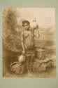 [Young African woman holding jugs]