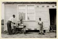 Man and child by a house with a dog